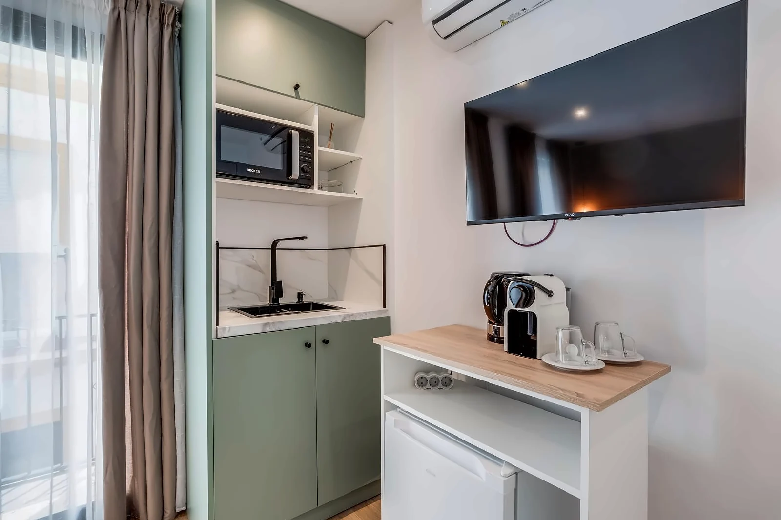 Room 3: a sink and a microwave in sage green cabinets, beside a Nespresso machine and kettle on a counter over the fridge