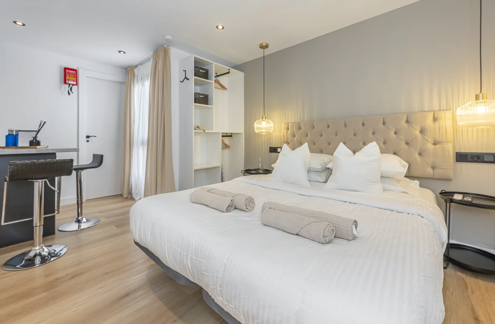 Room 4: the bed under two brass pendants, the open wardrobe and the breakfast bar by the window