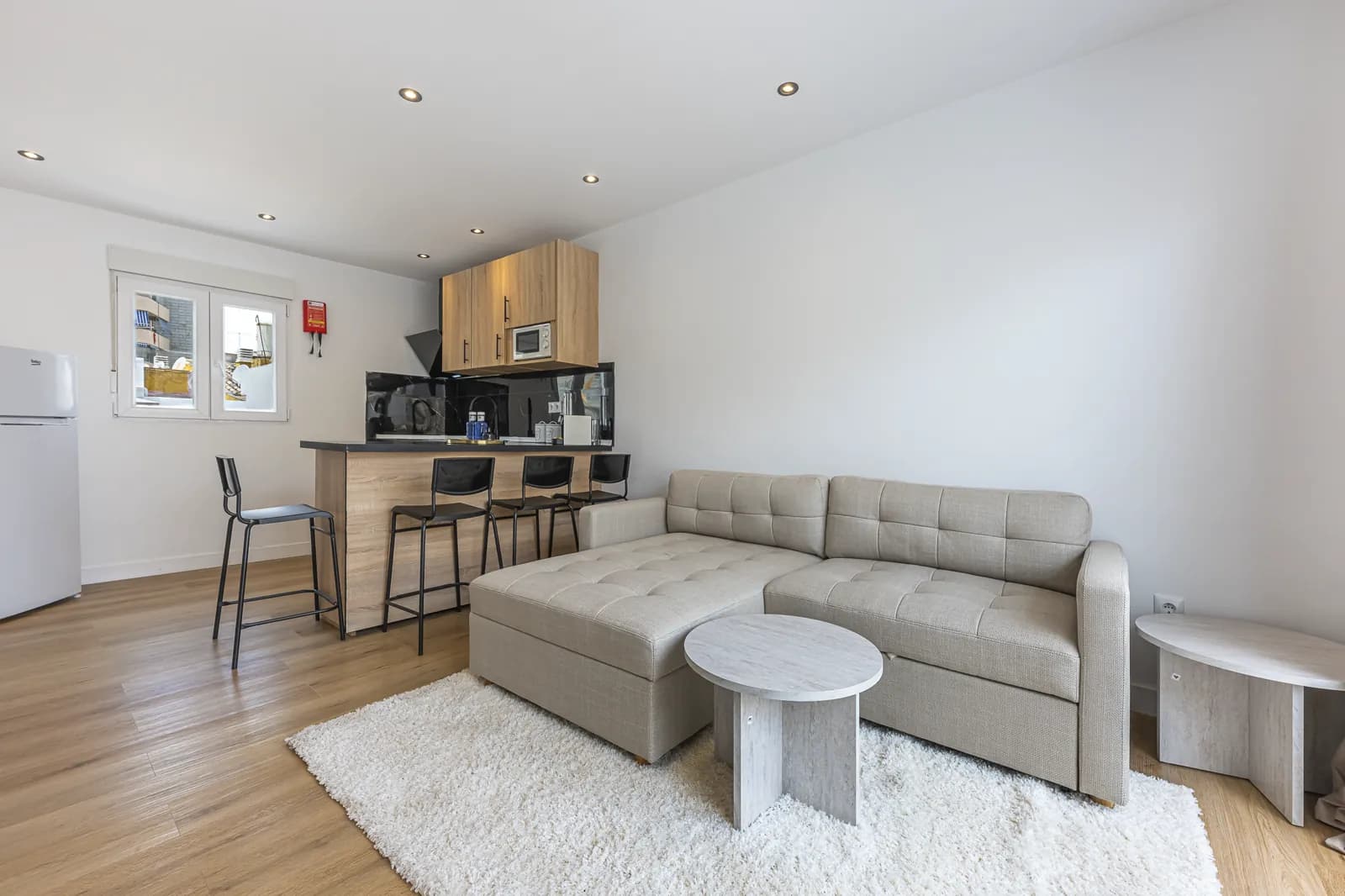 The One-Bedroom Suite: a corner sofa that opens into a bed, with the oak kitchen and its stools behind